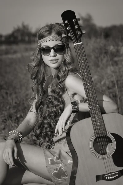 Jovem hippie menina em um campo de verão com sua guitarra — Fotografia de Stock