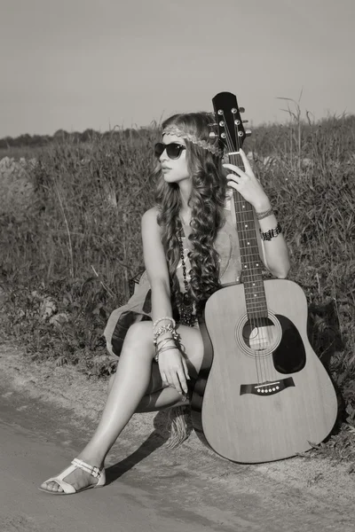 Young hippie girl on a summer field with her guitar — Stock Photo, Image