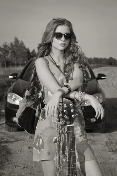 Attraktiva flicka reser med hennes gitarr — Stockfoto