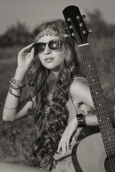 Jovem hippie menina em um campo de verão com sua guitarra — Fotografia de Stock