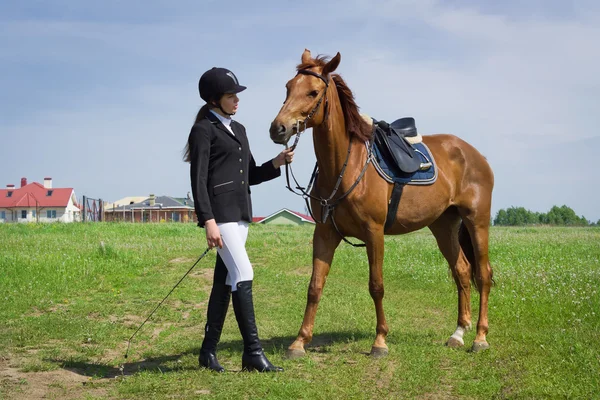 Beautiful young girl jockey talks with her horse — Stock Photo, Image