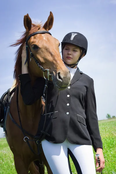 Beautiful young girl jockey talks with her horse — Stock Photo, Image