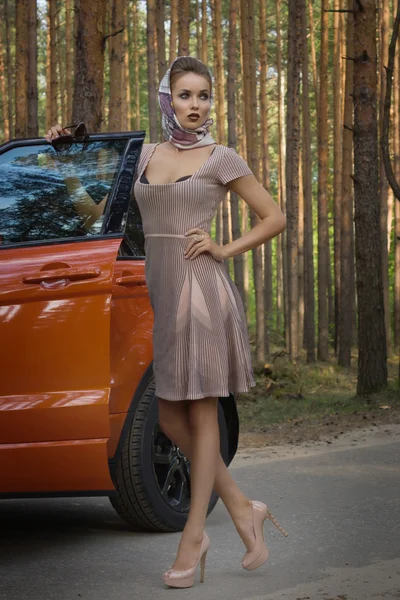 Señora en vestido vintage de pie cerca del coche —  Fotos de Stock