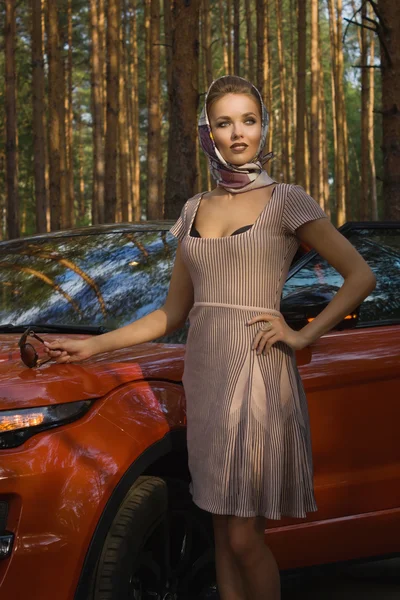 Леди в винтажном платье стоит возле машины — стоковое фото