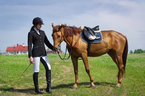 Schöne junge Jockeyspielerin mit ihrem Pferd — Stockfoto