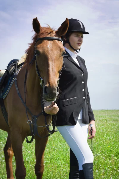 Schöne junge Jockeyspielerin mit ihrem Pferd — Stockfoto