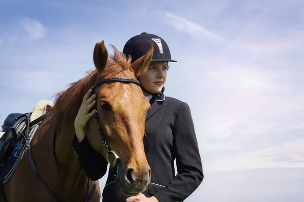 Schöne junge Jockeyspielerin mit ihrem Pferd — Stockfoto