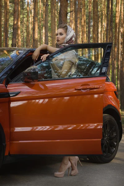 Fashion woman standing near vehicle with opened door — Stock Photo, Image