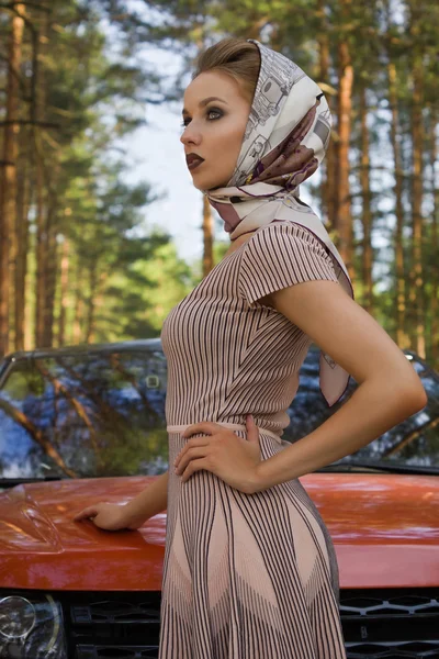 Pani w sukienka vintage stojący w pobliżu samochodu — Zdjęcie stockowe