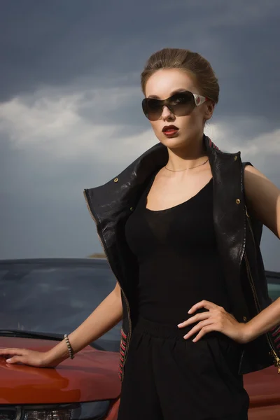 Модная женщина, стоящая рядом с автомобилем — стоковое фото