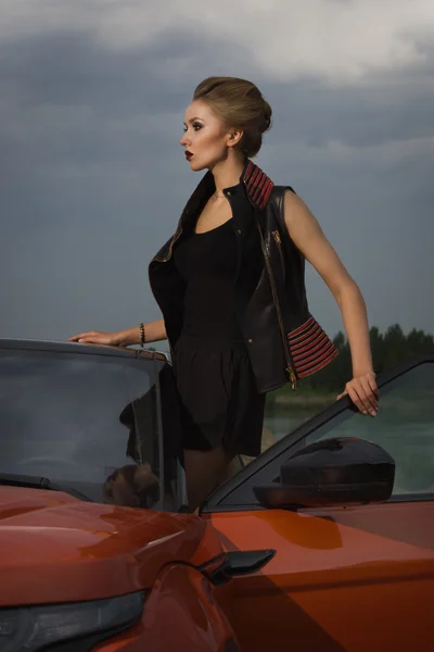 Fashion woman standing near vehicle with opened door — Stock Photo, Image