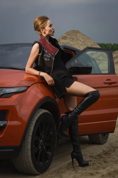 Fashion woman standing near vehicle with opened door — Stock Photo, Image