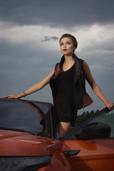 Mujer de moda de pie cerca del vehículo con puerta abierta —  Fotos de Stock