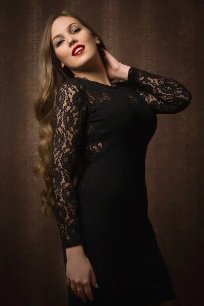 Mujer bonita en un vestido negro en la habitación oscura —  Fotos de Stock