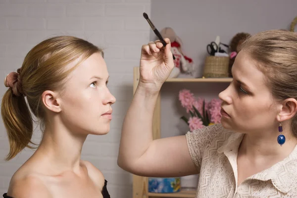 Make-up artista acabamento compõem a mulher bonita — Fotografia de Stock