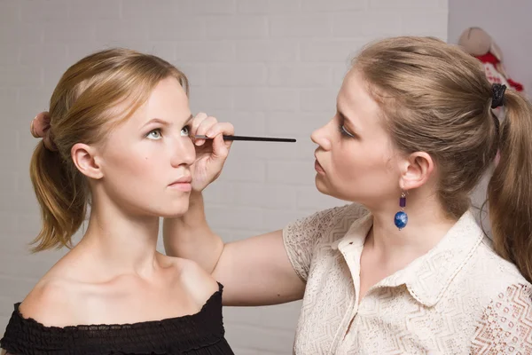 Maquiagem artista aplicando eyeliner líquido com escova — Fotografia de Stock