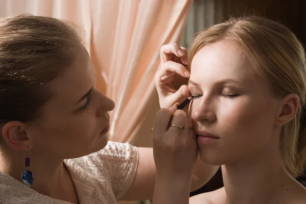 Maquiagem artista aplicando eyeliner líquido com escova — Fotografia de Stock