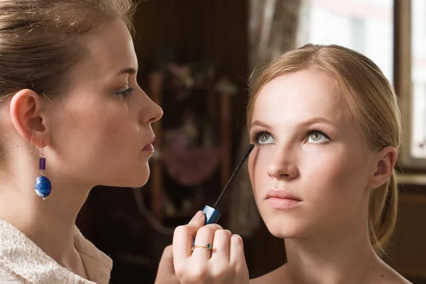 Maquiagem artista aplicando eyeliner líquido com escova — Fotografia de Stock