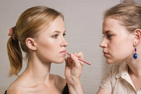 Vacker kvinna med läppstift som tillämpas av make-up artist — Stockfoto