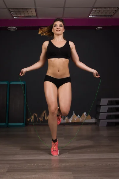 Chica en forma joven haciendo ejercicios con expansor en el gimnasio — Foto de Stock