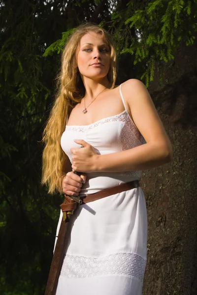 Menina bonita em vestido branco segurando uma espada medieval — Fotografia de Stock