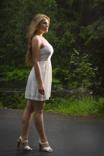 Mooi meisje lopen in groen park op regenachtige zomerdag — Stockfoto