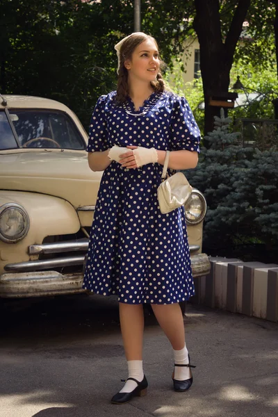 Señora en vestido vintage de pie cerca de coche retro —  Fotos de Stock