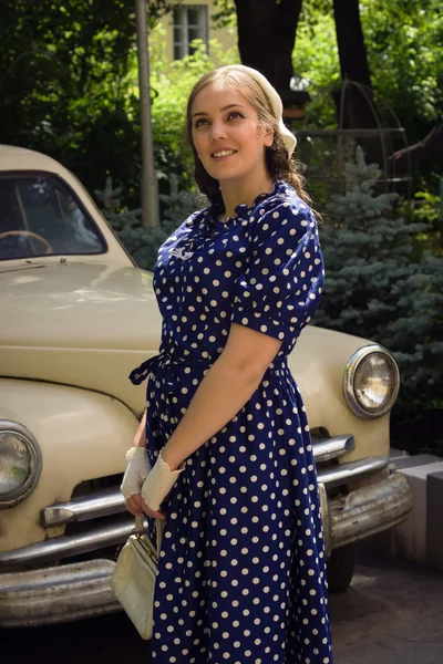 Lady in vintage jurk staande in de buurt van retro auto — Stockfoto