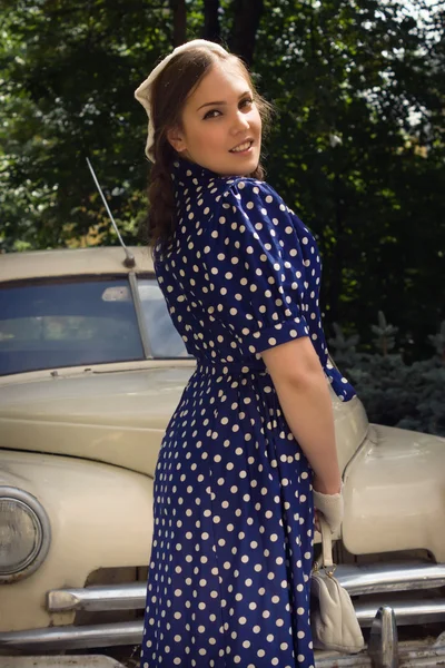 Senhora em vestido vintage de pé perto de carro retro — Fotografia de Stock