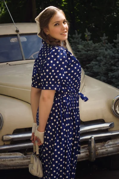 Senhora em vestido vintage de pé perto de carro retro — Fotografia de Stock