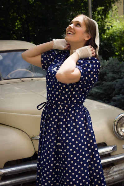 Señora en vestido vintage de pie cerca de coche retro —  Fotos de Stock