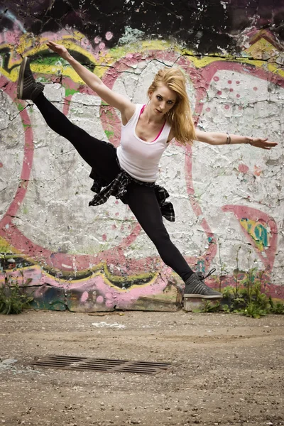 Chica joven bailando sobre fondo de graffiti —  Fotos de Stock