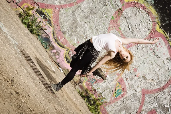 Chica joven bailando sobre fondo de graffiti —  Fotos de Stock