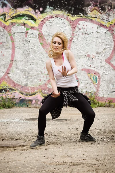 Young girl dancing on graffiti background — Stock Photo, Image