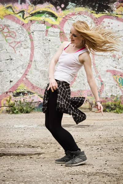 Chica joven bailando sobre fondo de graffiti —  Fotos de Stock