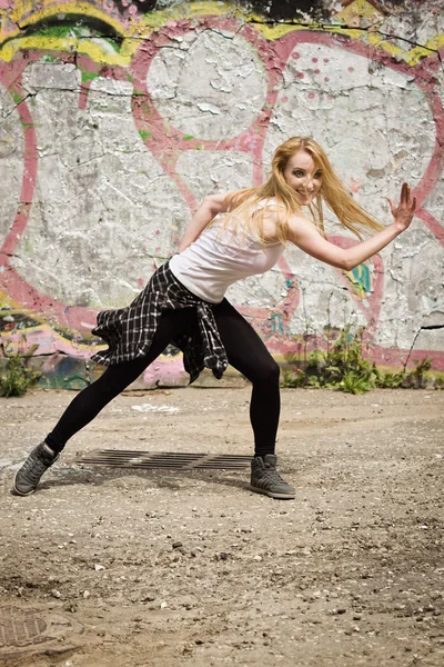 Chica joven bailando sobre fondo de graffiti — Foto de Stock