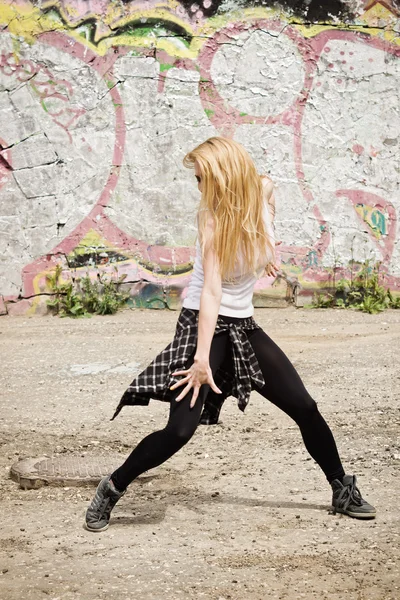 Młoda dziewczyna taniec na tle graffiti — Zdjęcie stockowe