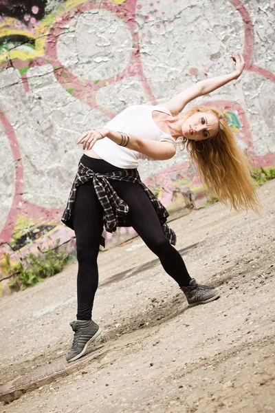 Mladá dívka tančí na graffiti pozadí — Stock fotografie