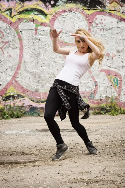 Chica joven bailando sobre fondo de graffiti —  Fotos de Stock