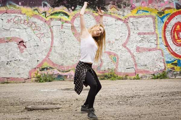 Ung flicka dansa på graffiti bakgrund — Stockfoto
