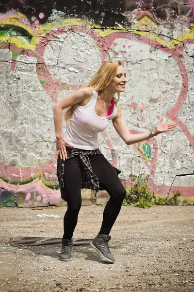 Young girl dancing on graffiti background