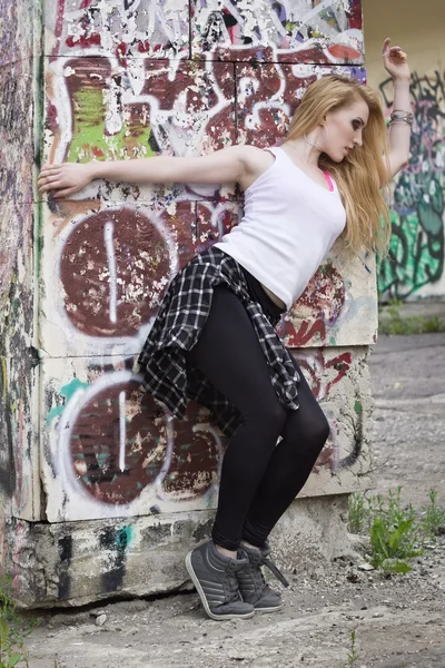 Mladá žena tanečnice na graffiti pozadí — Stock fotografie