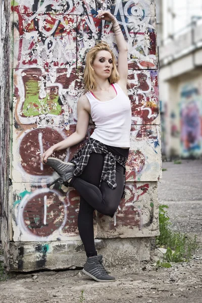 Mladá žena tanečnice na graffiti pozadí — Stock fotografie