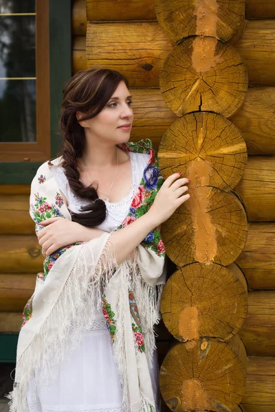 俄罗斯女人在小屋的背景 — 图库照片