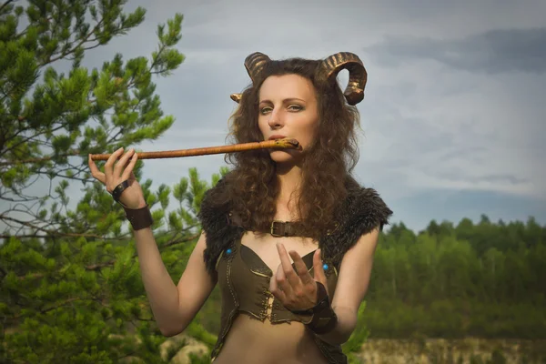 Красивая фавна играет на флейте — стоковое фото