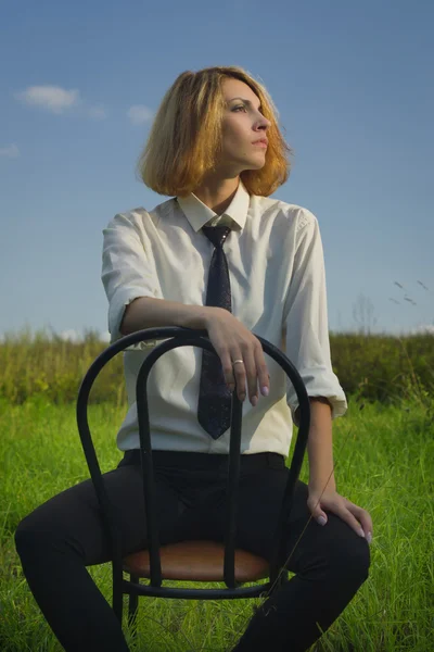 Mujer de belleza sentada en el sillón en el campo — Foto de Stock