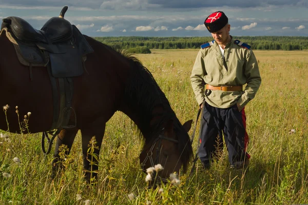 Russischer Kosak mit einem Pferd, das im Sommerfeld ruht — Stockfoto