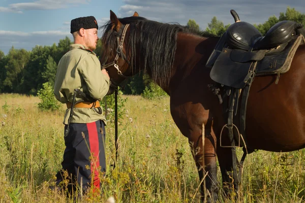 Russischer Kosak mit einem Pferd, das im Sommerfeld ruht — Stockfoto