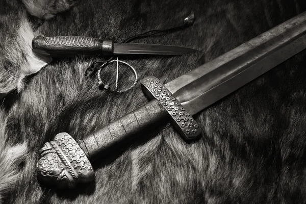 Vikingasvärd och kniv på en päls — Stockfoto