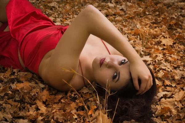 Девушка в красном платье в осеннем лесу — стоковое фото